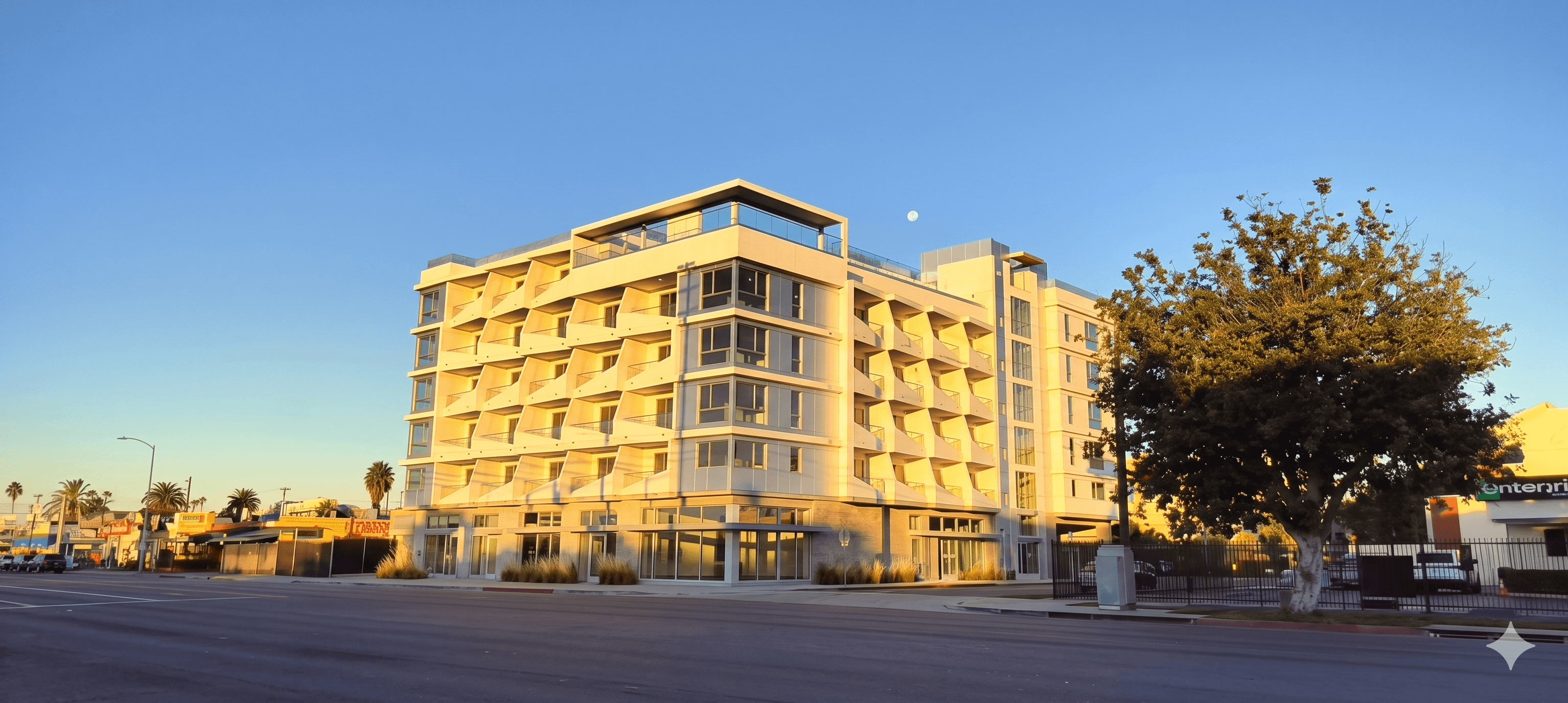 Ponte Luna Apartments building exterior at golden hour with the moon above.